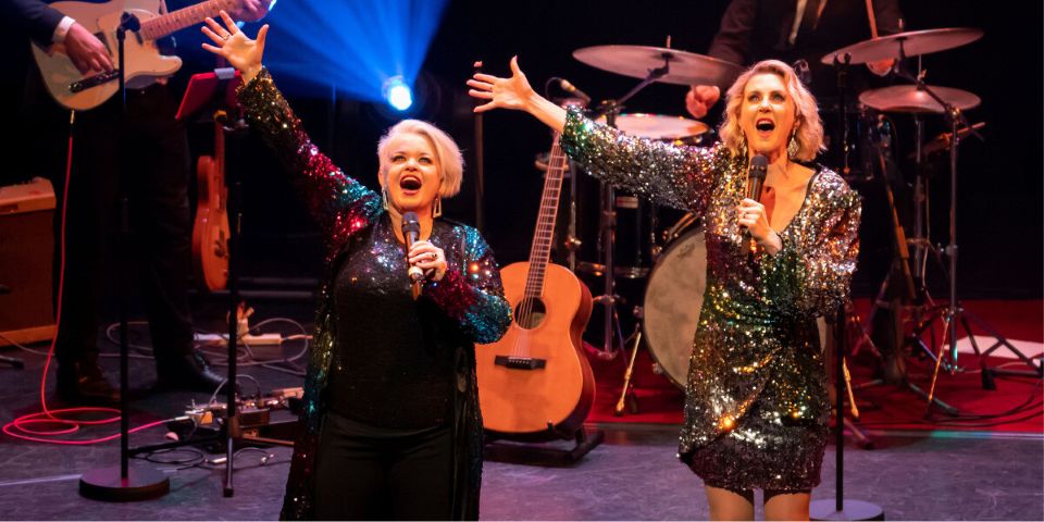 2 women singing on stage